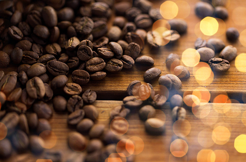 raw and agriculture concept - close up coffee beans on wooden table