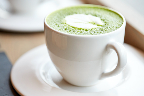 drink, weight loss, weight-loss and slimming concept - white cup of matcha green tea latte on table at restaurant or cafe