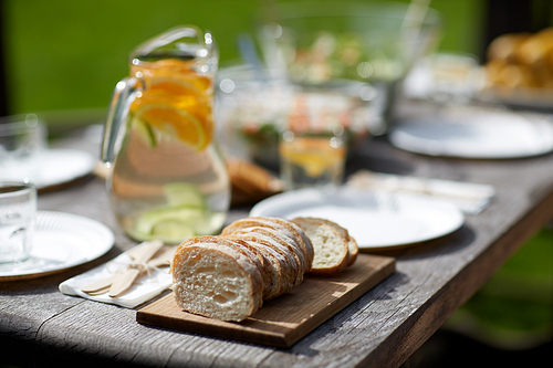 holidays, eating, mealtime and food concept - table with dinner at summer garden party