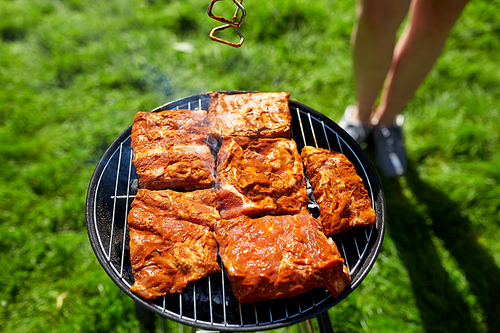 leisure, food, people and holidays concept - meat cooking on barbecue grill at summer party