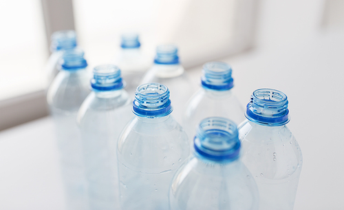 recycling, healthy eating and food storage concept - close up of clean empty used plastic water bottles on table