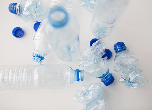 recycling, reuse, garbage disposal, environment and ecology concept - close up of empty used crashed plastic water bottles on table