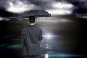 Composite image of rear view of classy businessman holding grey umbrella