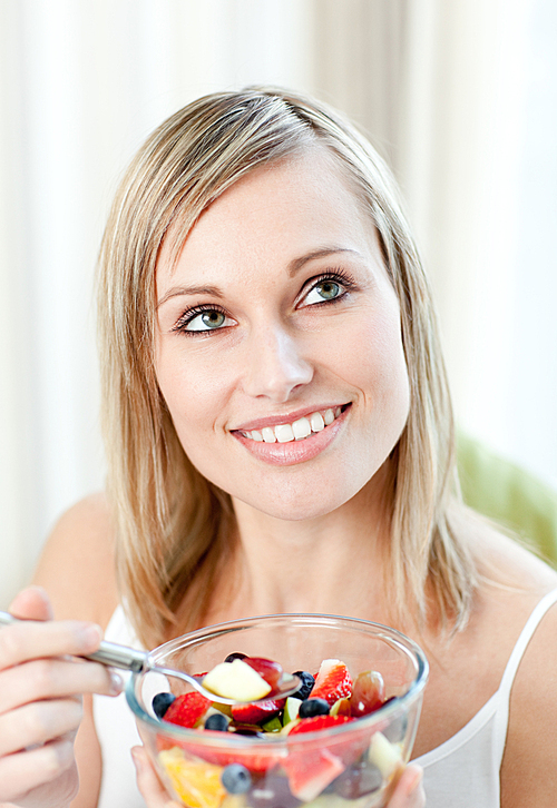 Radiant woman eating a fruit salad