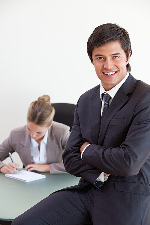 portrait-of-an-office-worker-posing-while-his-colleague-is-working