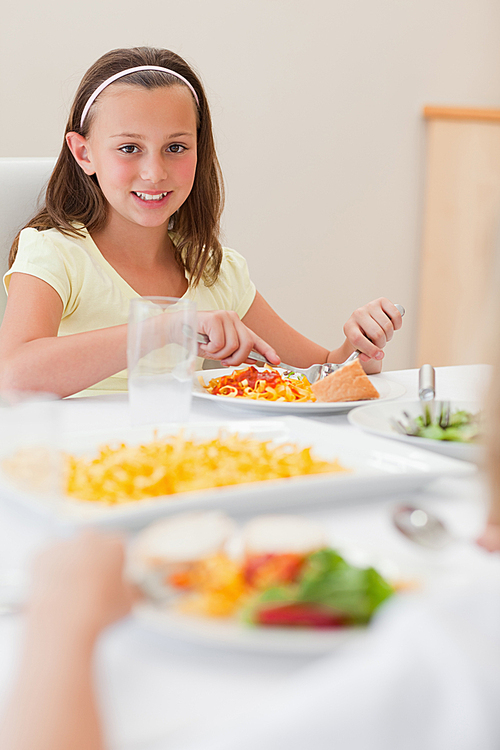 Happy girl having dinner at dinner table