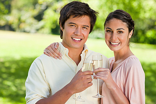 Two friends smiling while touching glasses of champagne