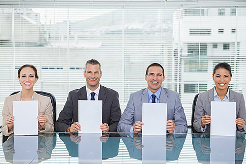 Smiling interview panel holding white paper