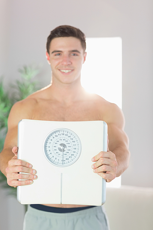 Confident smiling handsome man showing scales