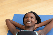 Smiling woman in gym clothes doing situps