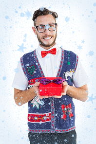 Composite image of geeky hipster offering christmas gift