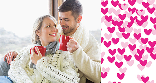 Composite image of loving couple in winter wear drinking coffee against window