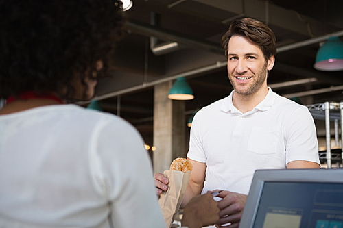 Customer paying her bread to waiter at the bakery