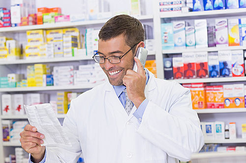 Happy pharmacist on the phone at the hospital pharmacy