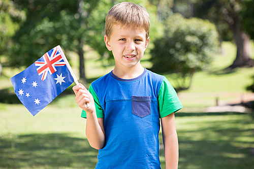 Little boy waving australian flag on a sunny day