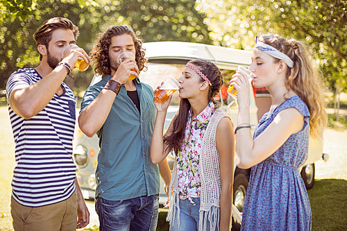 Hipster friends having a beer together on a summers day