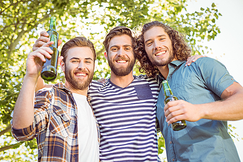 Hipster friends having a beer together on a summers day