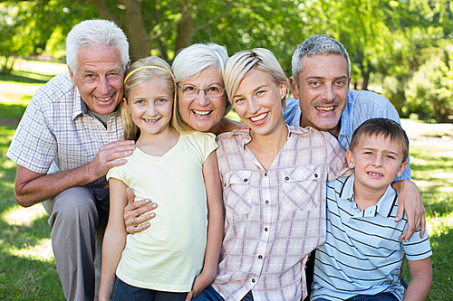 Happy family smiling at the camera on a sunny day