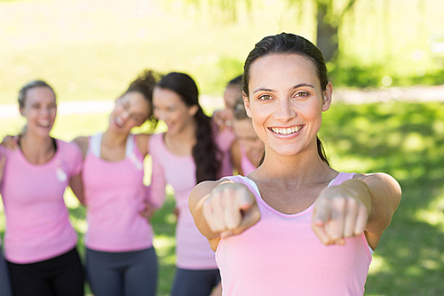 Smiling women in pink for breast cancer awareness on a sunny day