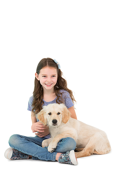 Happy little girl sitting with dog on her legs on white background