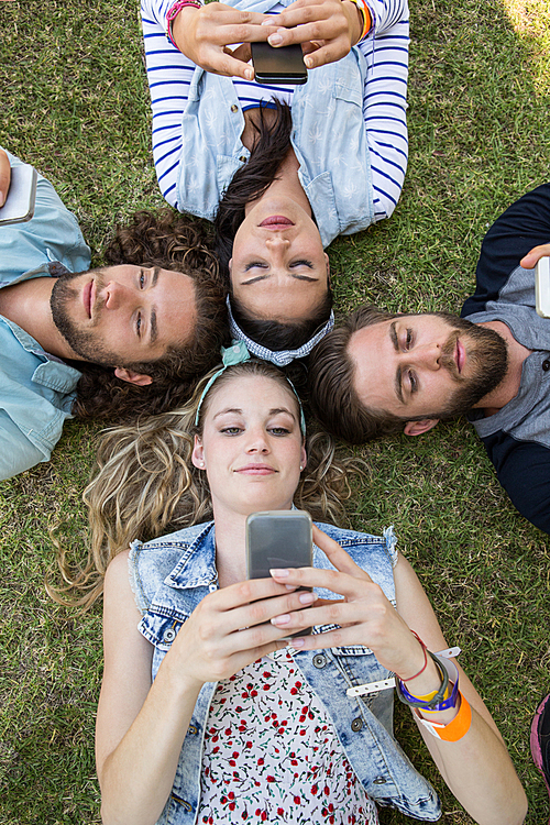 Happy friends lying on the grass on a summers day