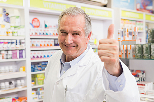 Positive pharmacist with thumb up in the pharmacy