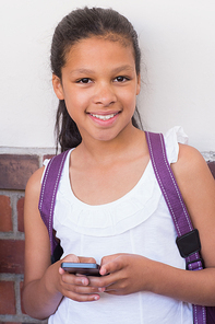 Cute pupil using mobile phone at the elementary school