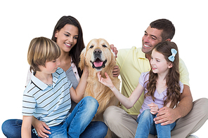 Happy family stroking dog over white background