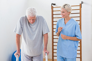 Therapist encouraging senior man in fitness studio