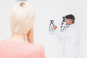 Blonde woman doing eye exam in medical office