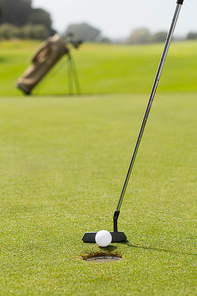 Golf club putting ball at the hole on a sunny day at the golf course