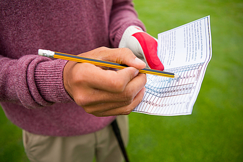 Golfer writing his points in paper in golf course