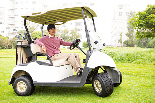 Golfer driving his golf buggy  at the golf course