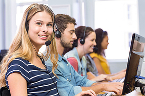 Side view of students using headsets in computer class