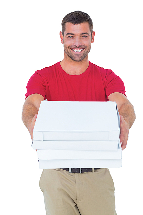Portrait of happy delivery man giving pizza boxes on white background