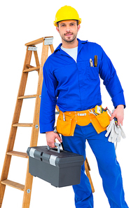 Smiling handyman holding tool box on white background