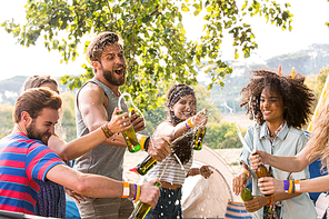 Hipsters spraying beer over each other on a sunny day