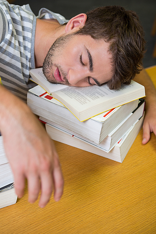 Student asleep in the library at the university