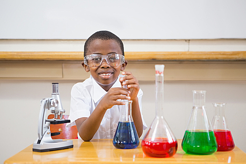 Cute pupil looking at liquids at elementary school