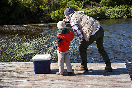 Happy man fishing with his son in the countryside