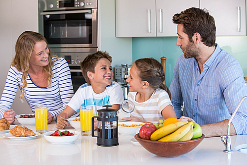 Happy family having breakfast together at home in the kitchen