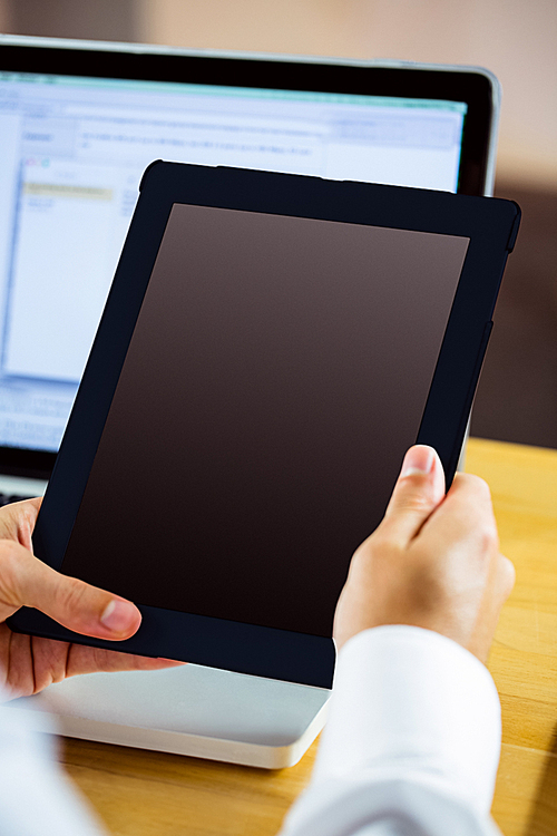 Man using laptop and tablet in close up