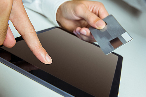 Man using tablet for online shopping in close up