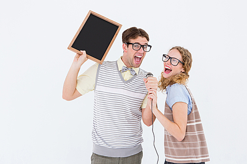 Geeky hipster couple singing into a microphone on white background