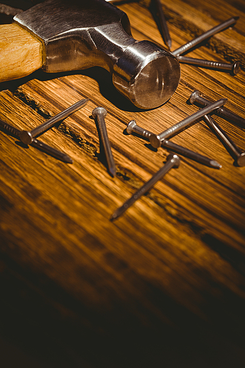 Hammer and nails laid out on table shot in studio