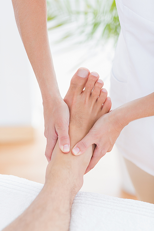 Physiotherapist doing foot massage in medical office