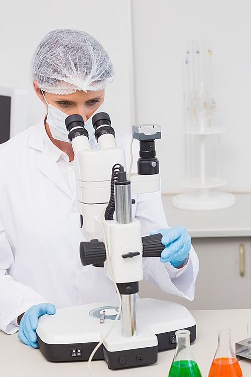 Scientist working attentively with microscope