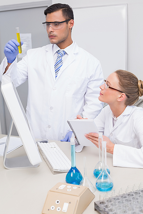 Scientists examining yellow precipitate in tube