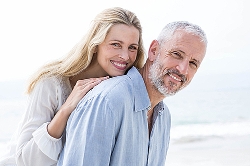 Happy couple hugging each other and smiling at camera