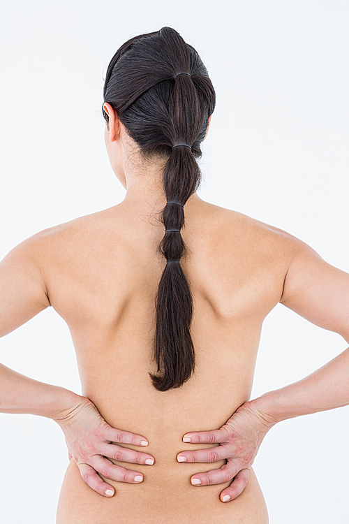 Brunette touching her painful back on white background
